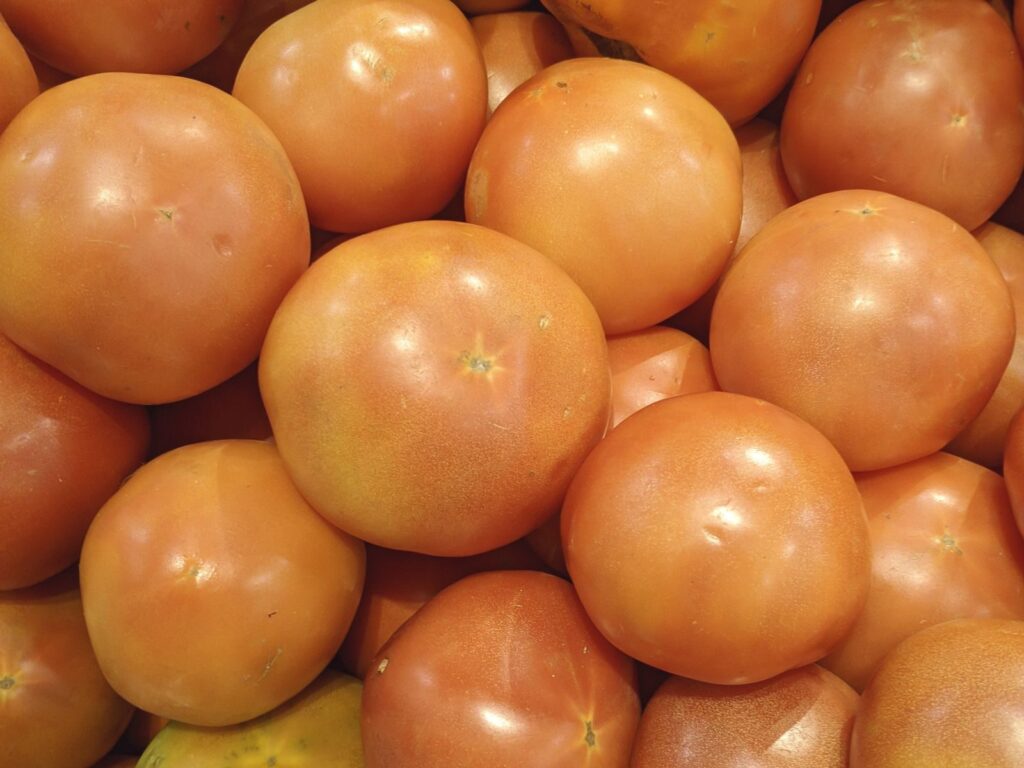 A vibrant collection of fresh, ripe tomatoes displayed in a market setting.